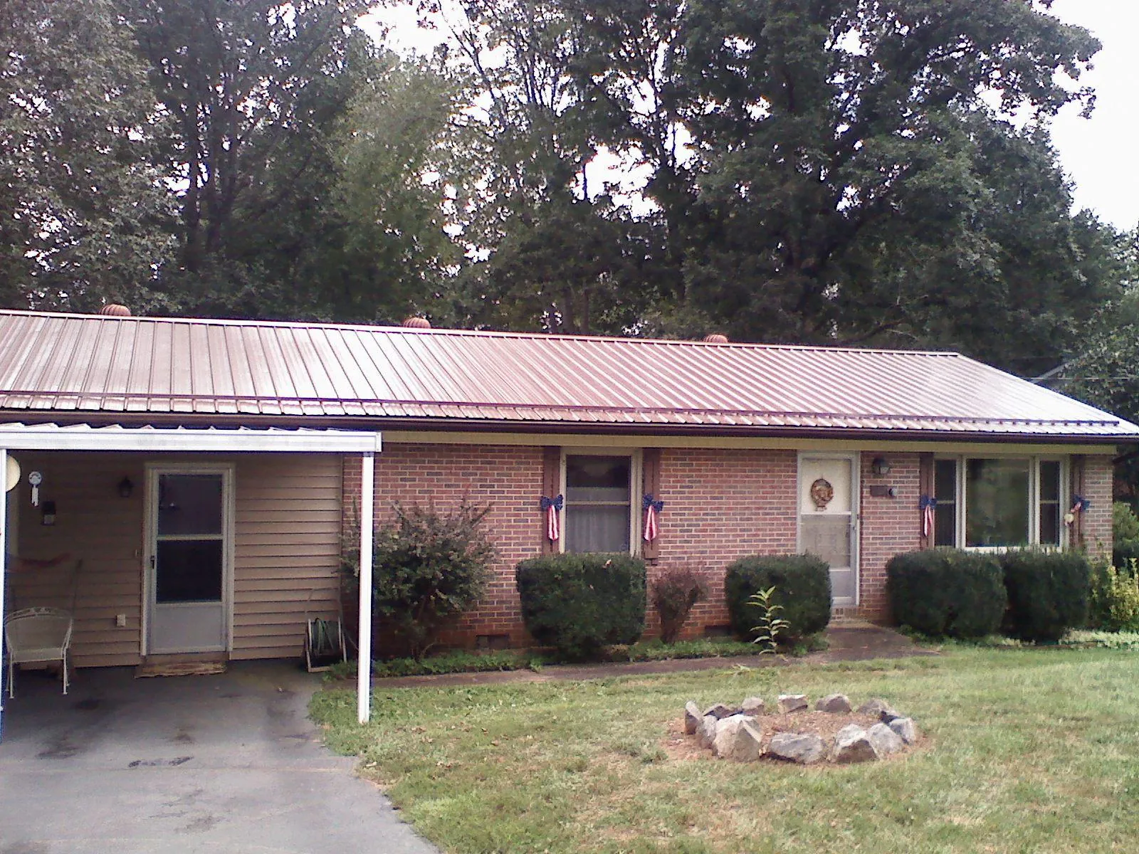 Bronze metal roof and carport on a brick ranch home — Roof Repair work by our crew in Hammond