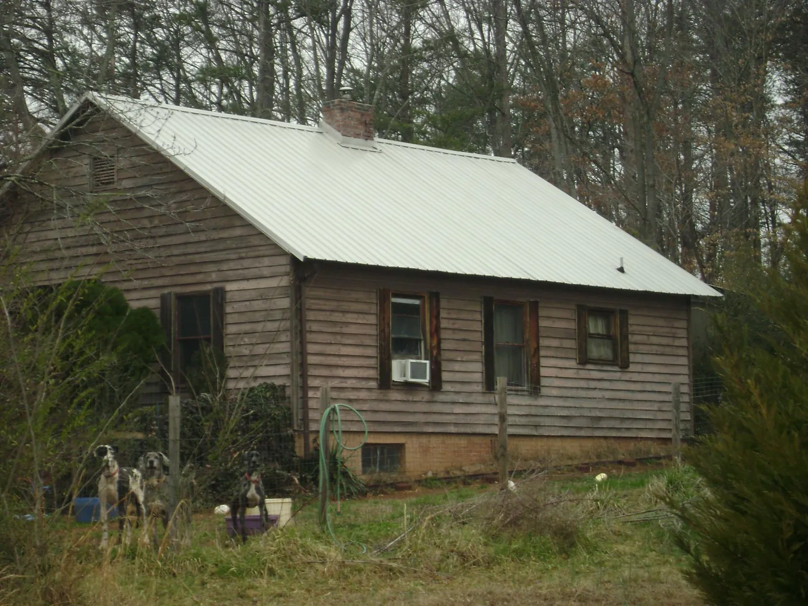 White metal roof on an old wood sided farmhouse, from a Metal Roof Installation job in Hammond