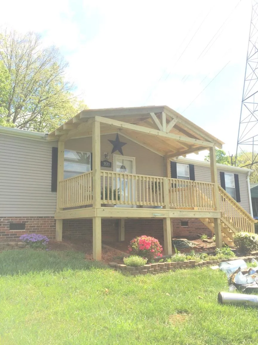 New gabled porch roof and deck railing added to a ranch home in Hammond